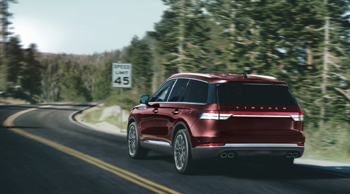 A 2024 Lincoln Aviator® SUV is being driven on a winding mountain road | Oliver Lincoln in Plymouth IN