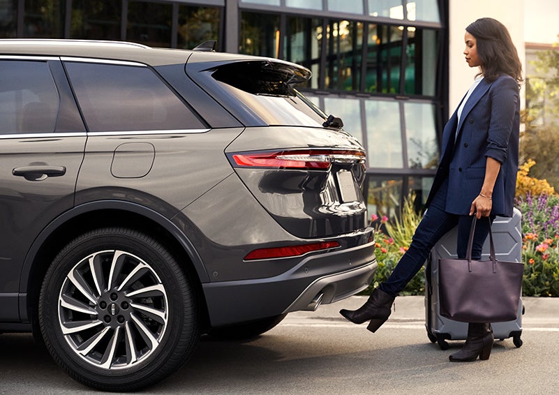 A woman with her hands full uses her foot to activate the available hands-free liftgate. | Oliver Lincoln in Plymouth IN