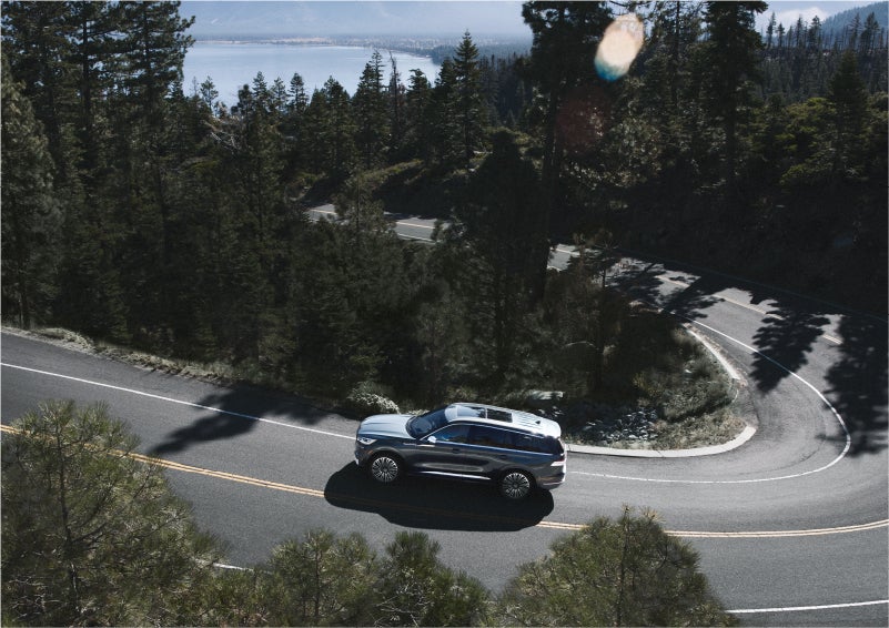 A 2023 Lincoln Aviator® SUV is being driven on a winding mountain road | Oliver Lincoln in Plymouth IN